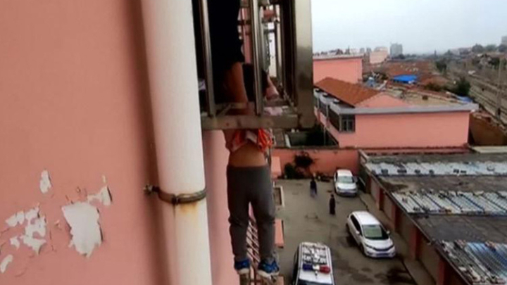 Bé trai bị kẹt đầu, lơ lửng ngoài cửa sổ tầng 4