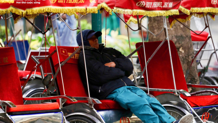 Người Hà Nội khoác áo mưa ra đường từ tờ mờ sáng trong gió rét đầu năm