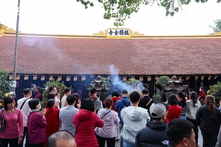 Tại chùa Trấn Quốc (quận Tây Hồ, Hà Nội), từ sáng sớm người dân và du khách đến du xuân, vãn cảnh, dâng hương lễ Phật, cầu mong bình an và xin lộc đầu năm.