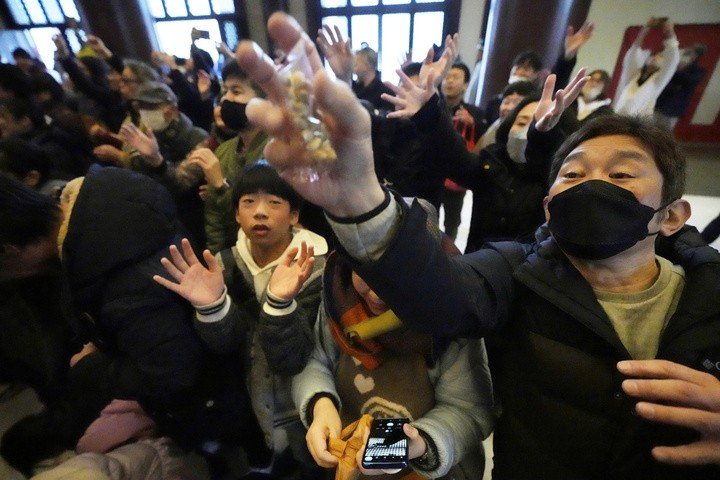 Người dân đang cố gắng bắt những hạt đậu may mắn. (Ảnh: AP)