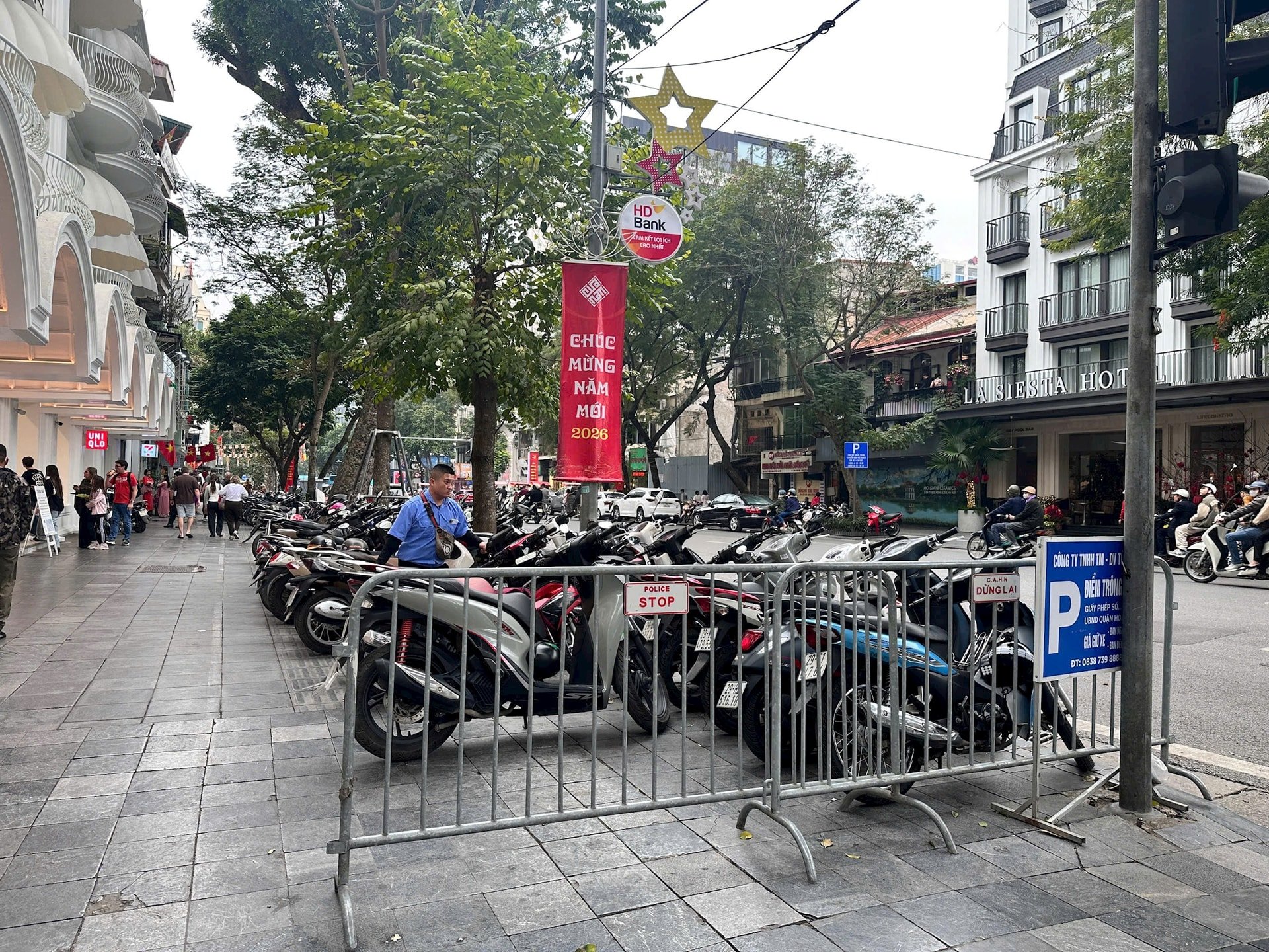 Điểm trông giữ xe máy có ghi biển của đơn vị khai thác điểm đỗ tại phố Bà Triệu (phường Cửa Nam) thu phí 20.000 đồng/xe máy. Ảnh: DN