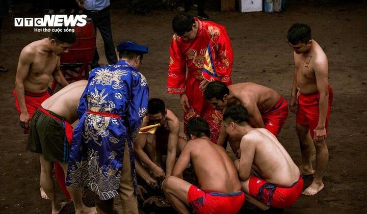 Quả cầu được hai đội đưa xuống một cái hố giữa sân để chờ khi có hiệu lệnh của trọng tài thì lấy lên để bắt đầu thi đấu. (Ảnh: Tô Mạnh)