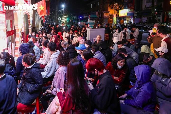 Lúc 5h30, khu vực chờ tại cửa hàng vàng Bảo Tín Minh Châu đã chật kín, dù trời lạnh và mưa phùn.