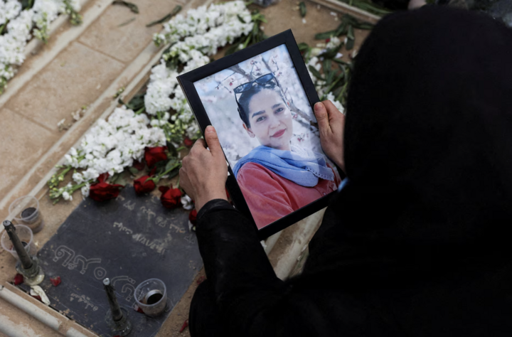 Người phụ nữ nhìn vào bức ảnh trong lễ tang các nạn nhân của các cuộc không kích Israel và Mỹ tại Tehran.