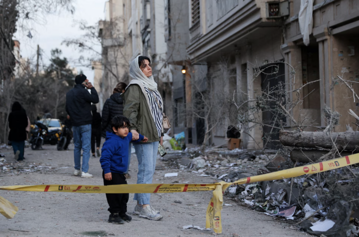 Người phụ nữ cùng con đứng nhìn hiện trường sau vụ không kích vào đồn cảnh sát tại Tehran, Iran.