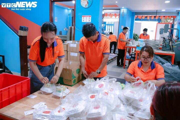 Nhân viên của anh Bách vừa làm việc vừa chuẩn bị các phần cơm miễn phí cho người nghèo.