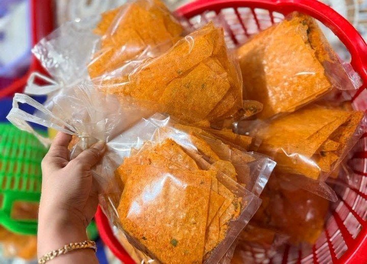 Chị Trang quyết định gom nhiều đơn hàng bánh tráng và đồ ăn vặt lại để giao một lần. (Ảnh: Đại Việt)