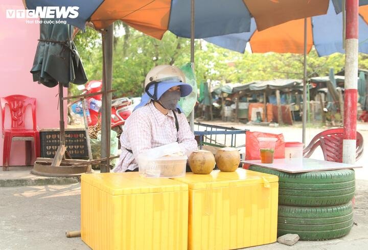 Tại góc vỉa hè trên đường phố phường Đồng Hới (Quảng Trị), chị Nguyễn Thị Luận, một người bán nước dạo, đang tranh thủ ngồi nghỉ dưới bóng râm nhỏ nhoi của chiếc ô che nắng. Gương mặt chị sạm đen, mồ hôi nhễ nhại sau lớp khẩu trang dày cộp.
