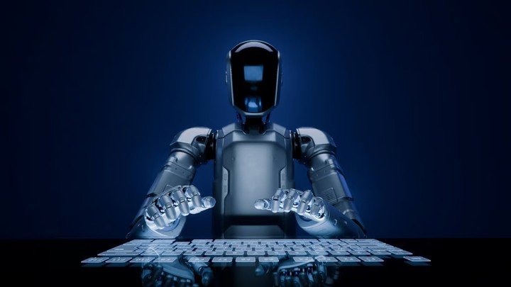 Một robot hình người được trang bị trí tuệ nhân tạo với tấm che mặt bằng kính đang gõ trên bàn phím cảm ứng hiện đại.