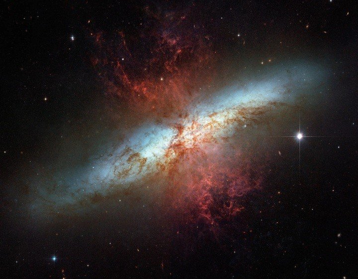 Hình ảnh tuyệt đẹp khác của M82 được chụp bởi kính viễn vọng Hubble. Màu đỏ trong hình ảnh thể hiện hydro và ánh sáng hồng ngoại, cho thấy hoạt động bùng nổ hình thành sao. Màu xanh lam và vàng lục thể hiện các bước sóng ánh sáng nhìn thấy được. (Ảnh: NASA)