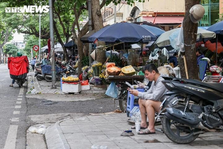 Nhiều hộ kinh doanh đã chủ động lùi hàng hóa vào khoảng một nửa vỉa hè, song việc để xe máy kèm theo vẫn chiếm dụng không gian, cản trở lối đi của người đi bộ.