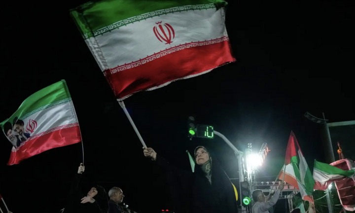 Người Iran mang theo quốc kỳ tham gia mít tinh tại thủ đô Tehran. (Ảnh: AP)