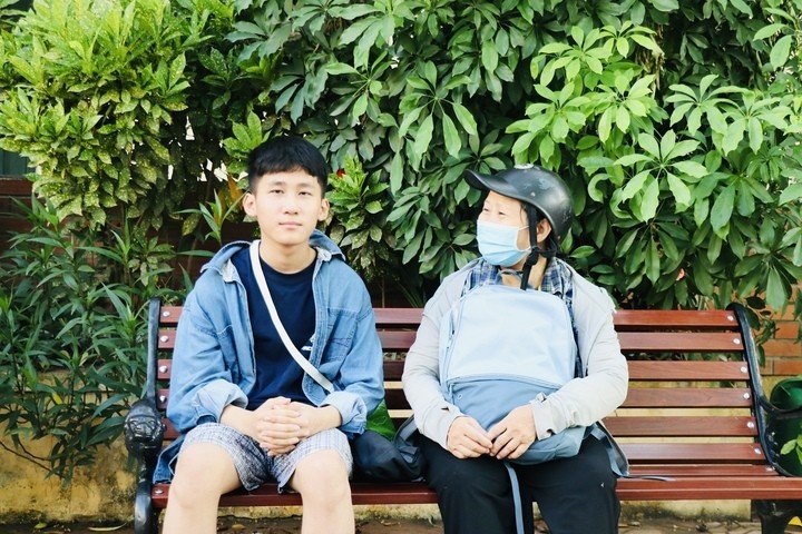 Chị Phạm Thị Hòa và con trai có mặt sớm nhất tại điểm trường THPT Đại Mỗ (phường Đại Mỗ).