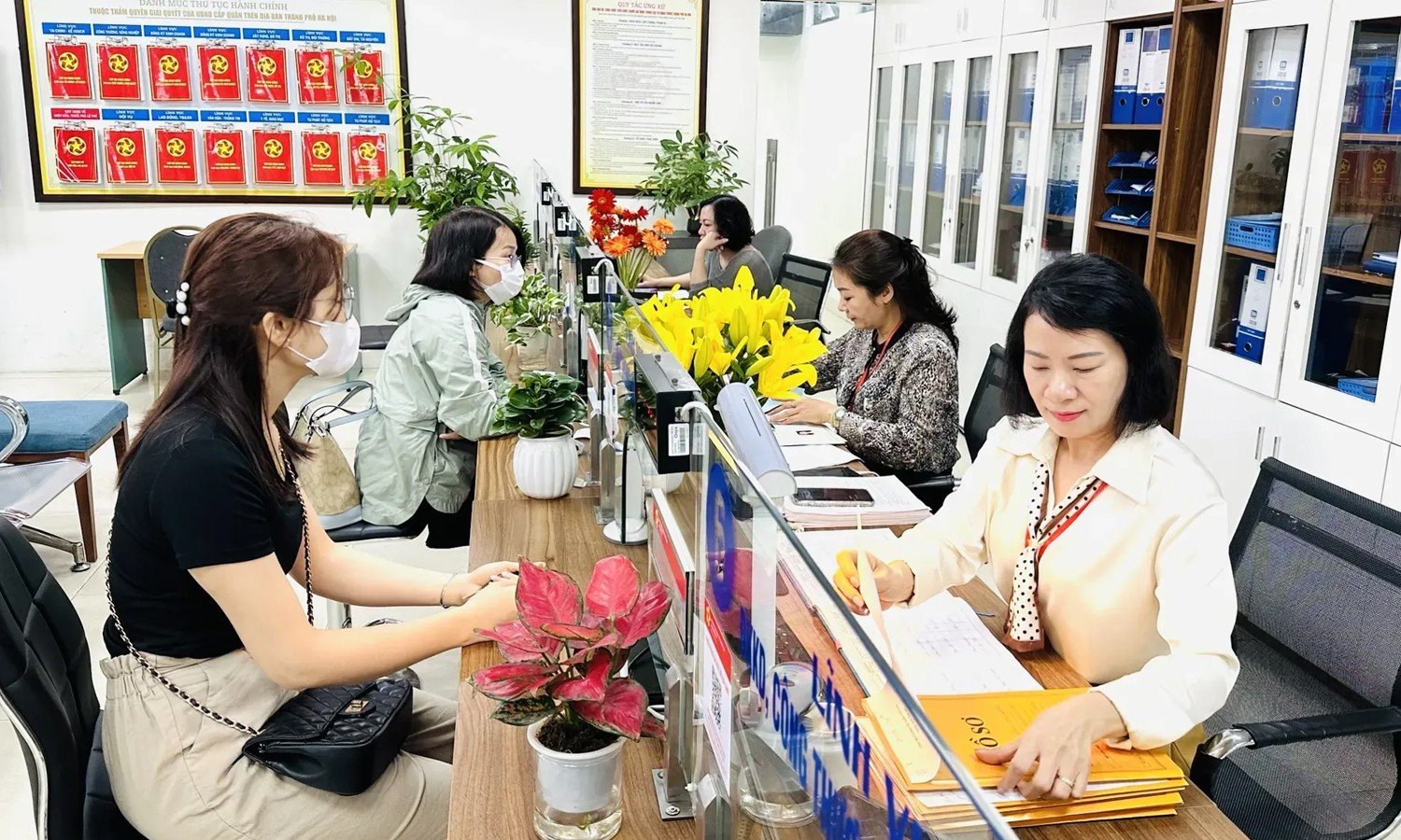 Công chức phường tại Hà Nội hỗ trợ người dân giải quyết thủ tục hành chính.