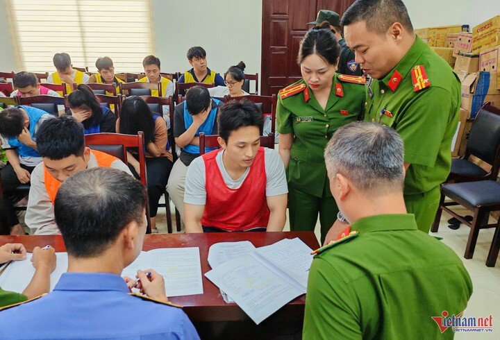 Đối tượng Hoàng Nhất Long (áo khoác đỏ), Giám đốc Công ty Sunland Travel, làm việc với cơ quan công an. (Ảnh: T.D)
