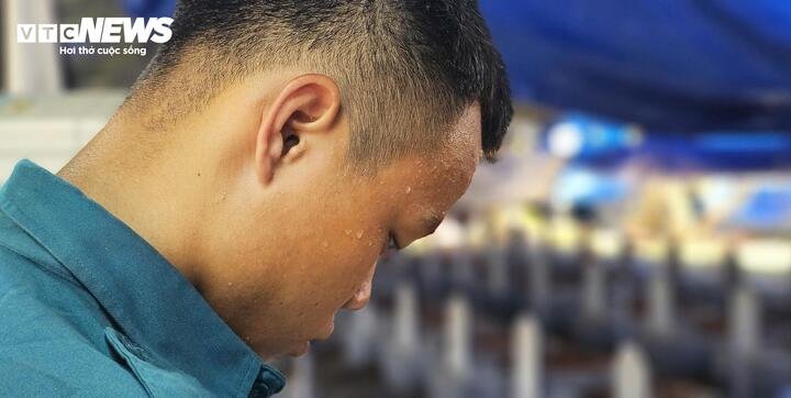 Giữa ngày hè tháng 6, những giọt mồ hôi không làm giảm đi sự tập trung của cán bộ thực hiện các bước lấy mẫu ADN từ di cốt liệt sĩ. (Ảnh: Tiến Thắng)