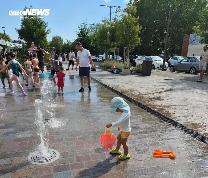 Trẻ em vui chơi giải nhiệt tại đài phun nước công cộng ở Nanterre, Pháp. (Ảnh: Duy Quân)