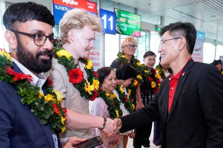 Lãnh đạo Vietjet tặng hoa và chào đón hành khách trên chuyến bay đầu tiên.