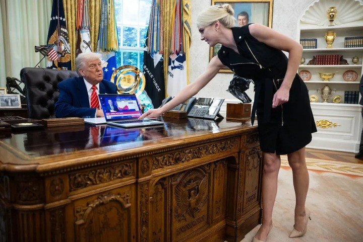 Tổng thống Donald Trump quan sát trợ lý Natalie Harp đặt chiếc máy tính đang phát bản tin về thị trường chứng khoán trong cuộc họp báo tại Phòng Bầu dục thuộc Nhà Trắng vào ngày 30/5/2025.