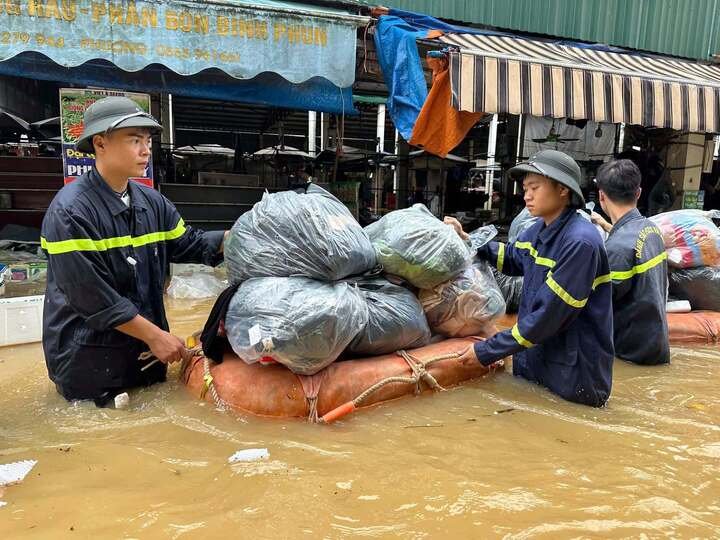Lực lượng chức năng đang di chuyển tài sản ra khỏi chợ bị ngập. (Ảnh: Công an Lạng Sơn).