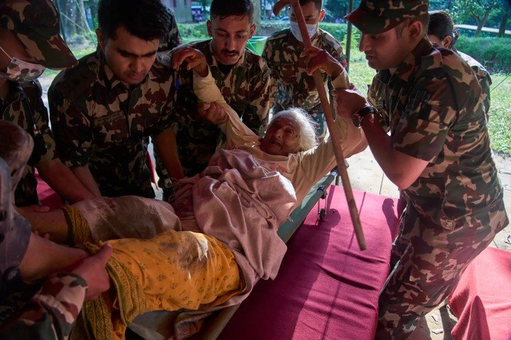 Người sống sót sau trận lũ quét được đưa đến bệnh viện dã chiến để điều trị. (Ảnh: AP)