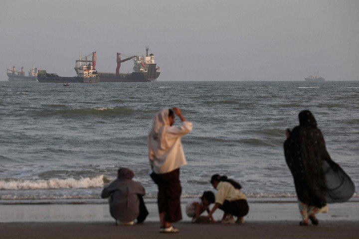 Người dân Iran đứng nhìn tàu bè qua eo biển Hormuz. (Ảnh: Reuters)