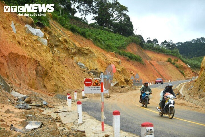 Một đoạn đường bị sạt lở nghiêm trọng với những hàm ếch lớn ăn sâu vào vách núi cao dựng đứng ngay sát mặt đường có nhiều xe cộ qua lại.