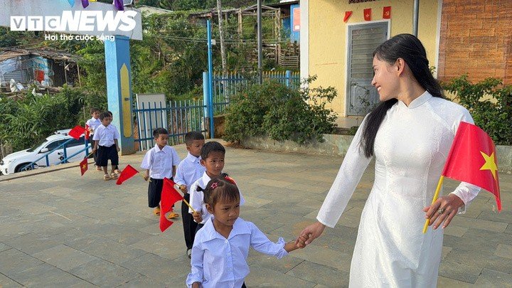 Cô Trà Thị Thu nắm tay nhóm học sinh lớp 1 tiến vào sân trường.