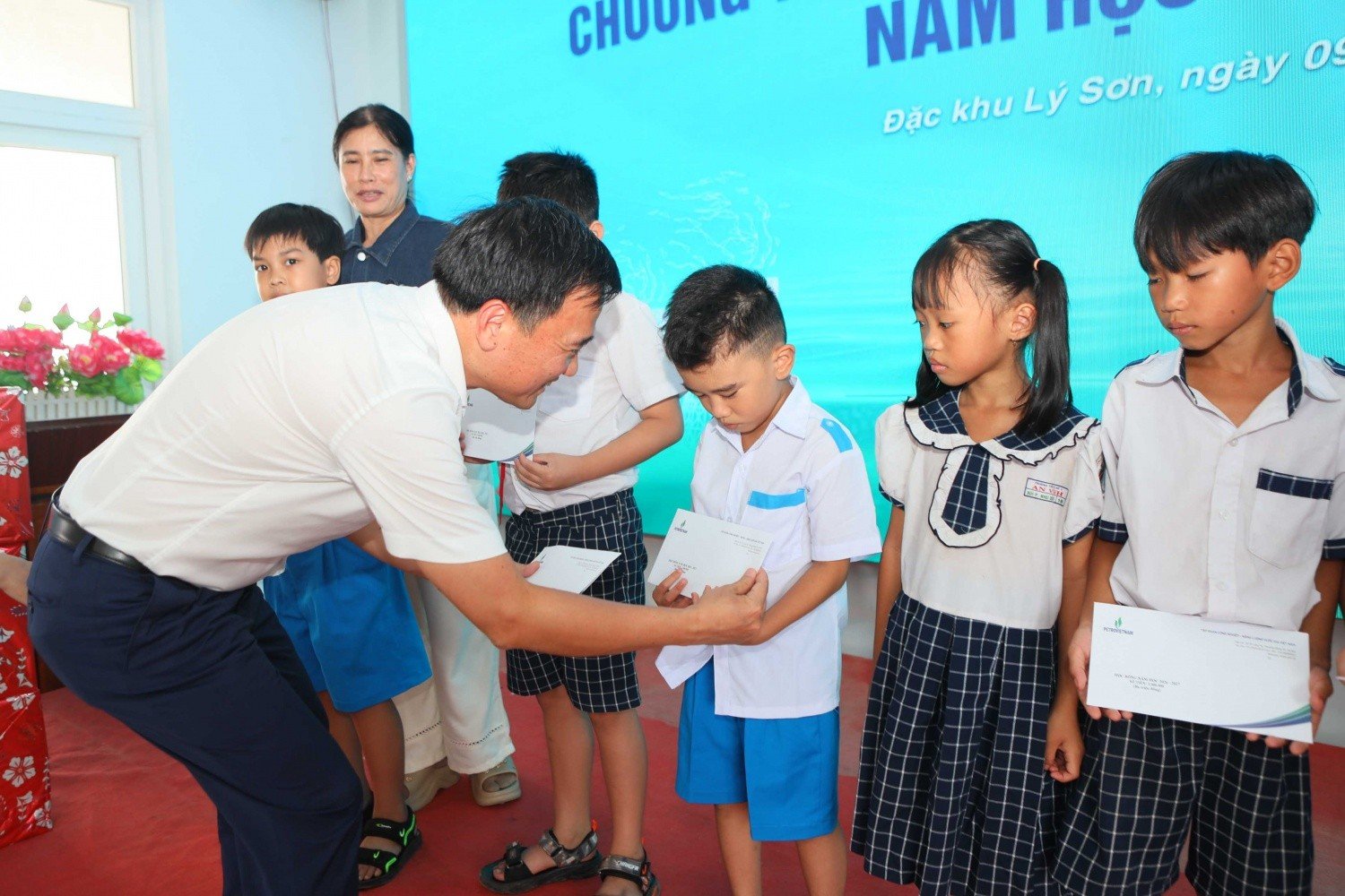 Ông Vũ Anh Tuấn, Phó Chủ tịch Công đoàn PETROVIETNAM trao tặng học bổng cho các học sinh.
