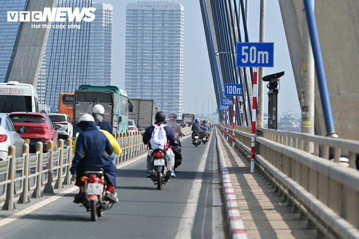 Mỗi vị trí trên thành cầu Nhật Tân có 5 biển báo thể hiện các mốc 0, 50, 100, 150 và 200m. Tương ứng với các biển báo là những vạch sơn trên mặt đường để tài xế ước lượng khoảng cách với xe phía trước. (Ảnh: Minh Tuệ)