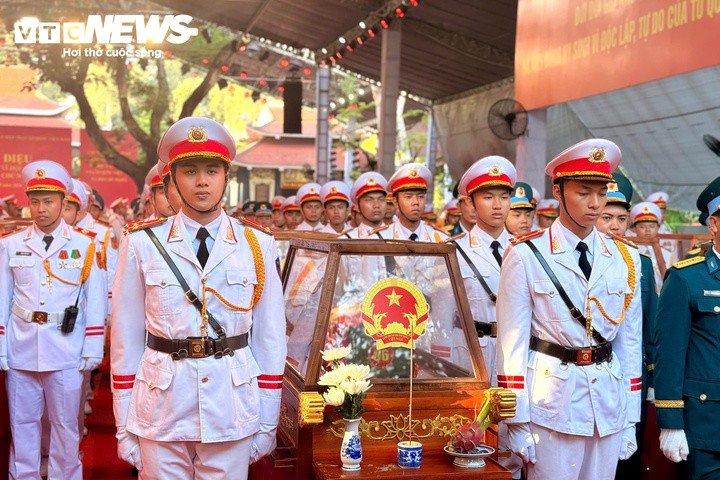Các chiến sĩ tiêu binh trong quân phục trắng đứng trang nghiêm bên quách đựng hài cốt liệt sĩ, chuẩn bị thực hiện nghi thức trong lễ truy điệu.