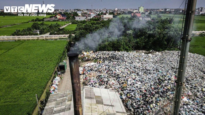 Khói bốc lên từ bãi rác xã Hải Hưng, theo hướng gió lan về phía đường dân sinh và khu dân cư gần đó.
