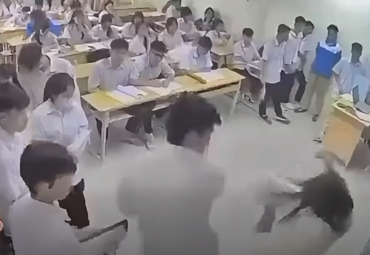 Cô giáo bất ngờ bị một nam sinh lao lên bục giảng, đấm vào đầu trong giờ học tại Trường THPT Mạc Đĩnh Chi, Hà Nội (Ảnh: Cắt từ clip).