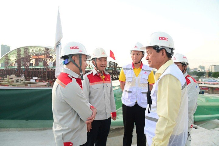 Ông Trịnh Tiến Dũng, Chủ tịch Tập đoàn Đại Dũng (bìa phải) động viên người lao động trước thời khắc hợp long cầu đi bộ.