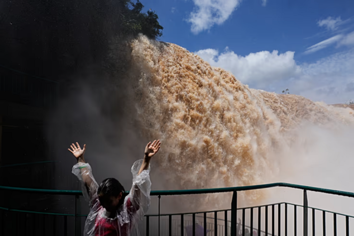 Du khách đứng trên lối đi bộ nhìn ra thác Iguazu. (Ảnh: AP)