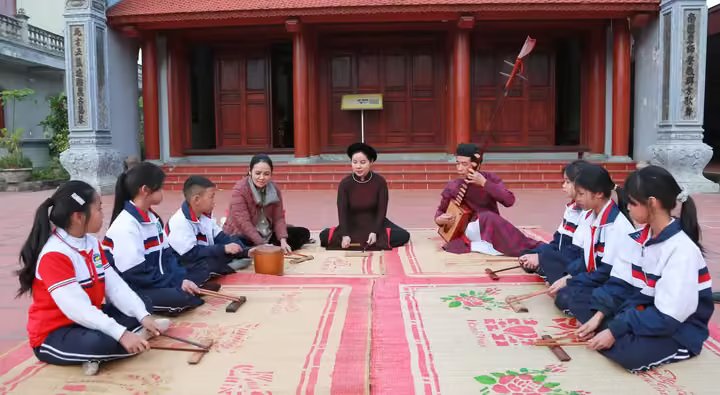 Học sinh Trường Tiểu học Hòa Bình (phường Hòa Bình, TP Hải Phòng) học ca trù cùng các ca nương, kép đàn của Câu lạc bộ Ca trù Đông Môn. (Ảnh: TTXVN)