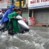 Nước chảy cuồn cuộn trên phố Sài Gòn sau cơn mưa 30 phút