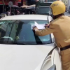 Cảnh sát giao thông dán giấy phạt trên kính xe
