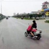 Nữ \'ninja\' chở con nhỏ vừa lái xe vừa buông tay cởi áo mưa trên quốc lộ khiến người xem thót tim